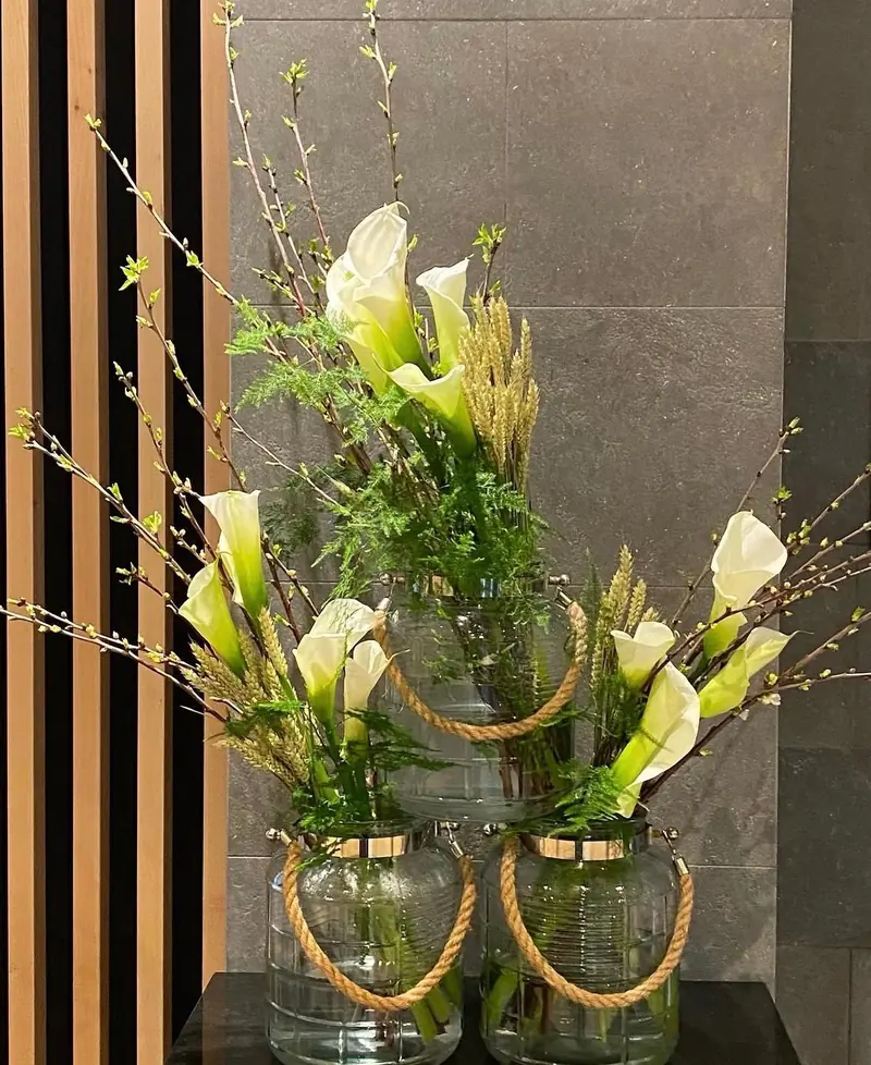 Arums blancs dans des vases cerclés de corde