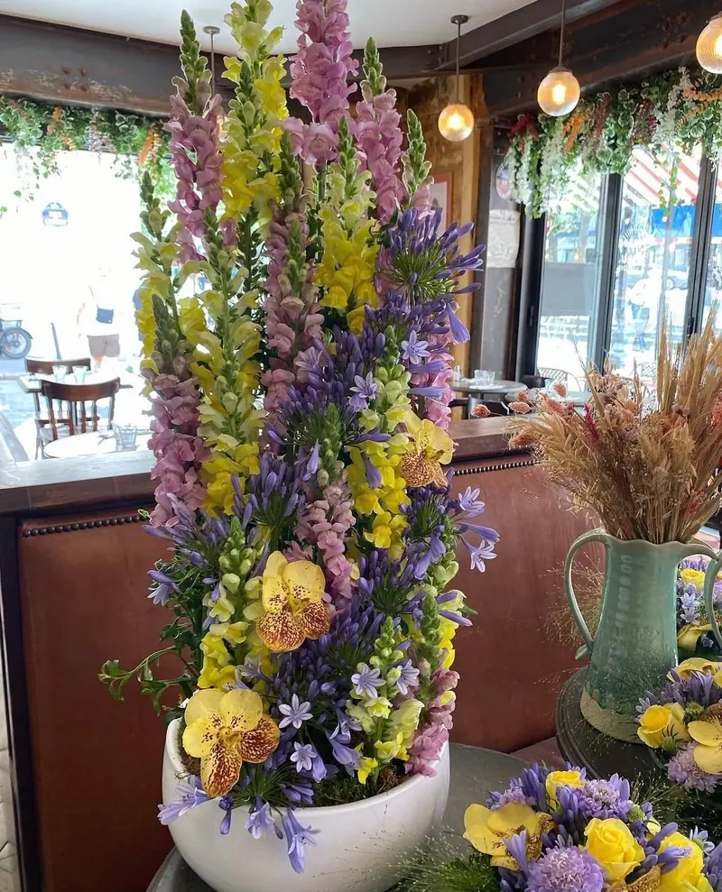 Haute composition de delphiniums et de fleurs jaunes dans un restaurant