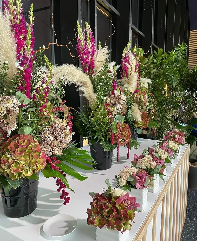 Compositions de glaïeuls, hortensias et pampas alignées sur une balustrade