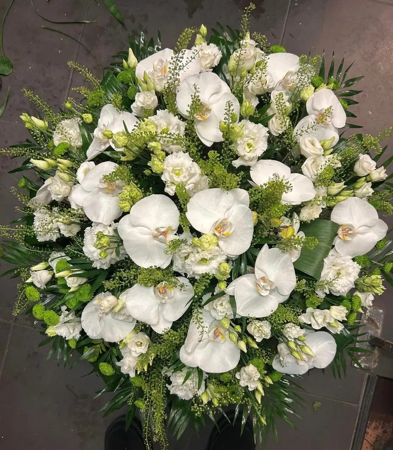 Coussin de deuil d'orchidées, roses et lisianthus blancs