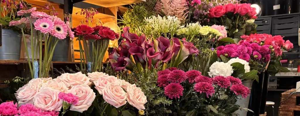 L'étal de la boutique : roses, gerberas, arums et œillets
