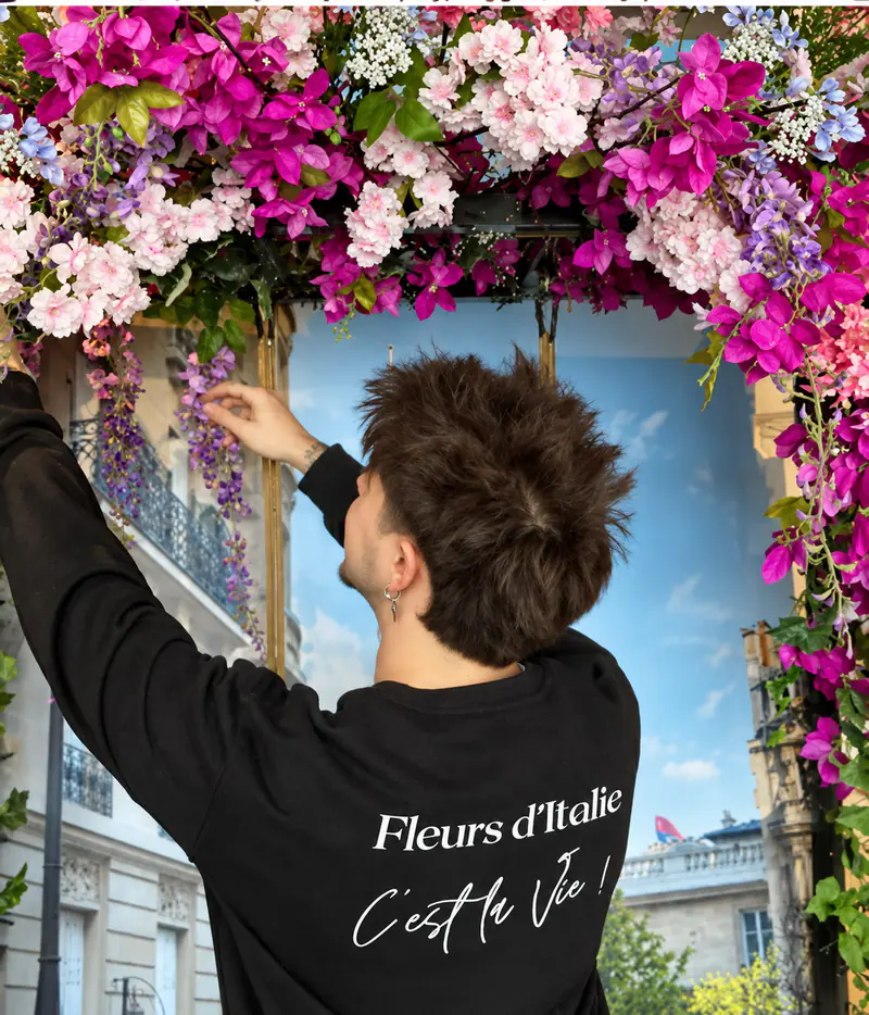 Fleuriste Fleurs d'Italie installant une arche florale rose — « C'est la Vie ! »