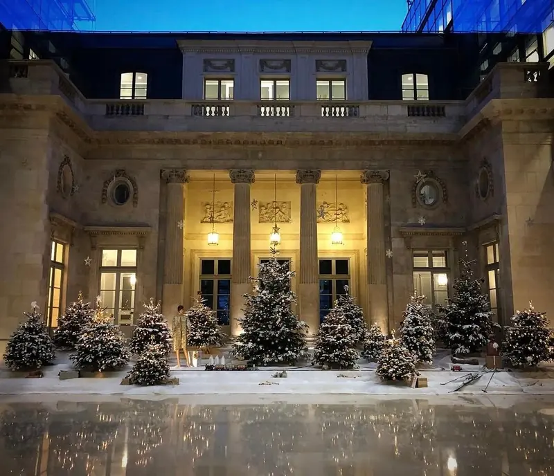 Sapins de Noël enneigés dans la cour d'un hôtel particulier parisien